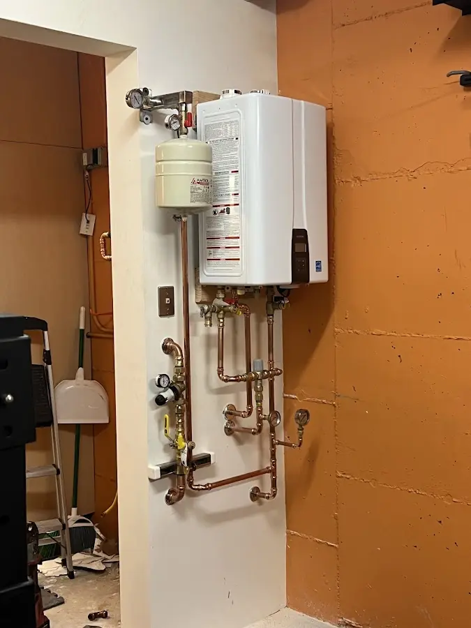 Plumbing technician inspecting water heater connections in Pea Ridge